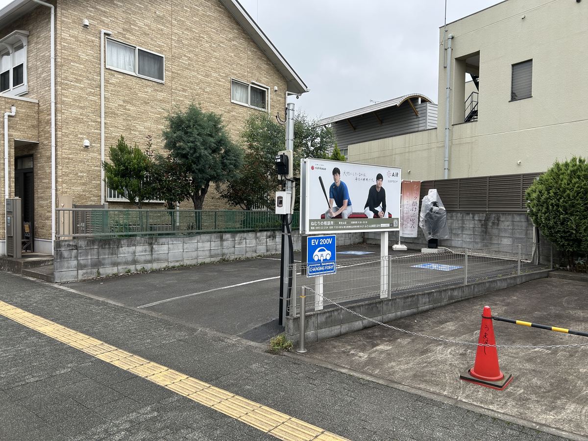 駐車場①。店舗横・駅側のスペース。電気自動車の充電スタンドと、ねむりの相談所の看板が目印です。